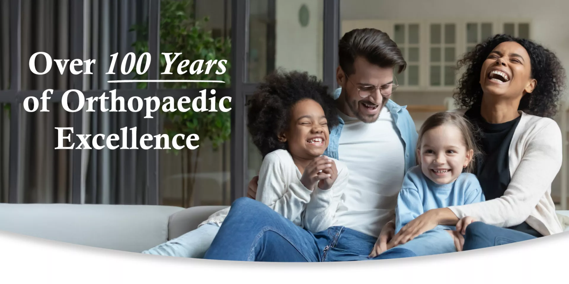 Over 100 Years of Orthopaedic Excellence: Interracial family laughing together